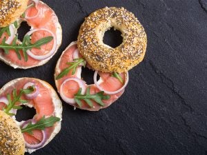 Three Bruegger's Bagels sandwiches with salmon, onions, and lettuce